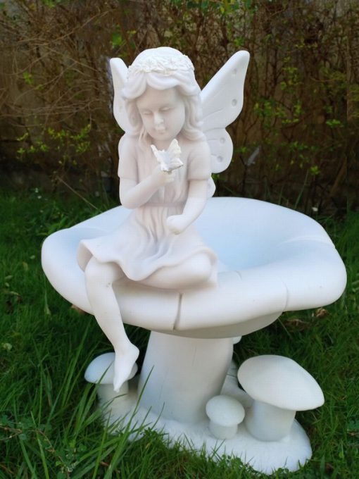 A young Fairy sits atop a toadstool.