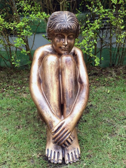 Statue of a young lady sitting in thought with a bronze finish.