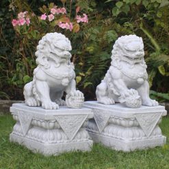 Two far eastern dragon dogs atop stone plinths.