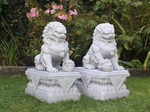 Two far eastern dragon dogs atop stone plinths.